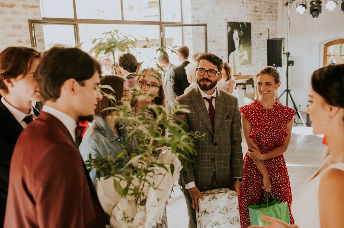Grupa osób w eleganckich strojach na przyjęciu.