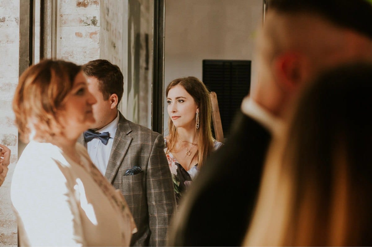 Grupa ludzi na przyjęciu w eleganckich strojach.