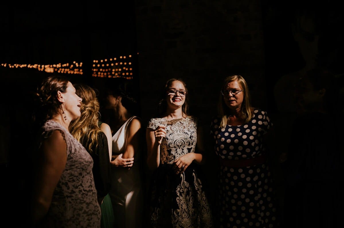 Grupa kobiet w eleganckich sukniach na przyjęciu.