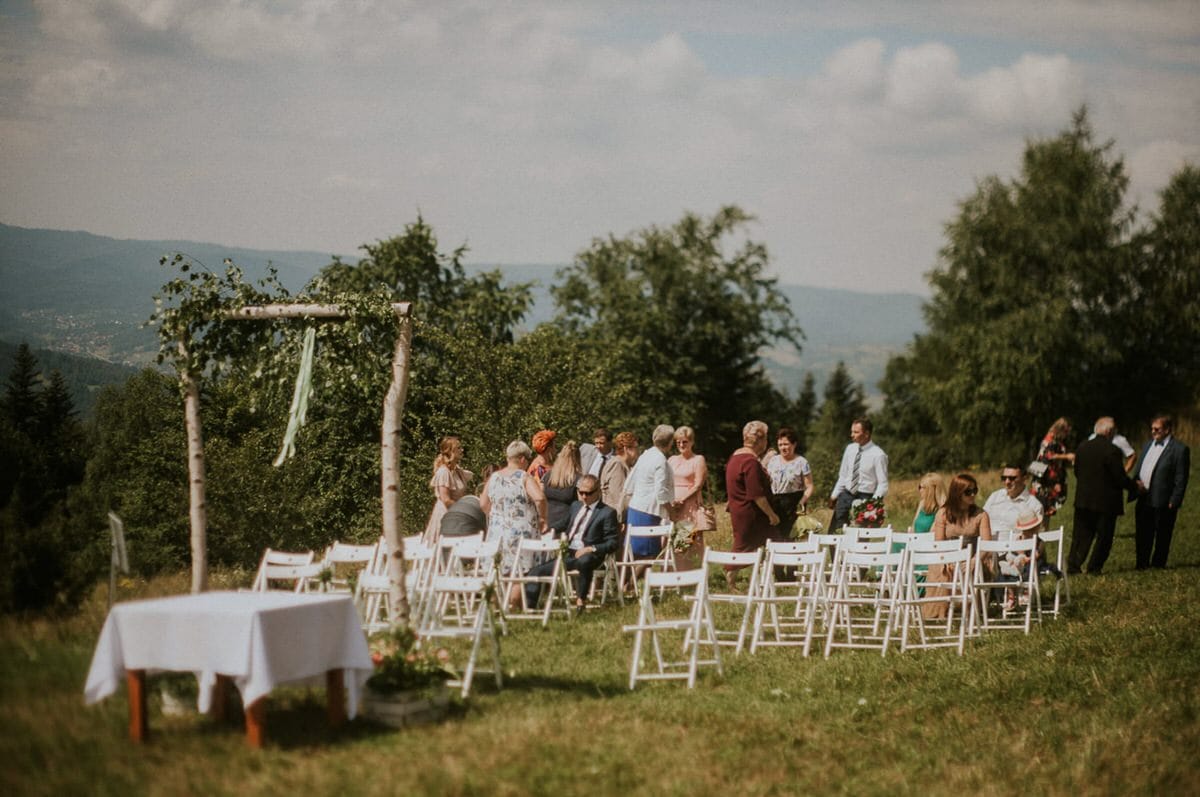 Goście weselni na plenerowej ceremonii w górach.