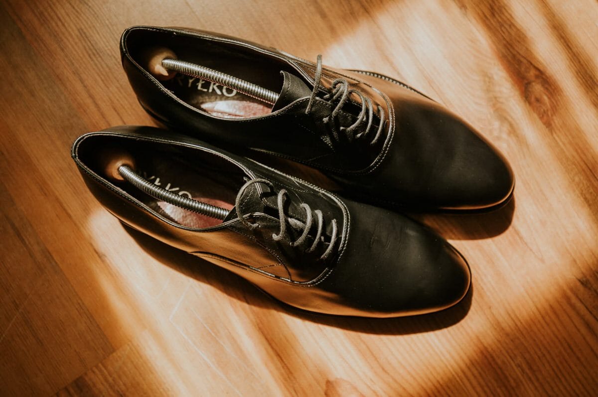 Czarne skórzane buty na drewnianej podłodze