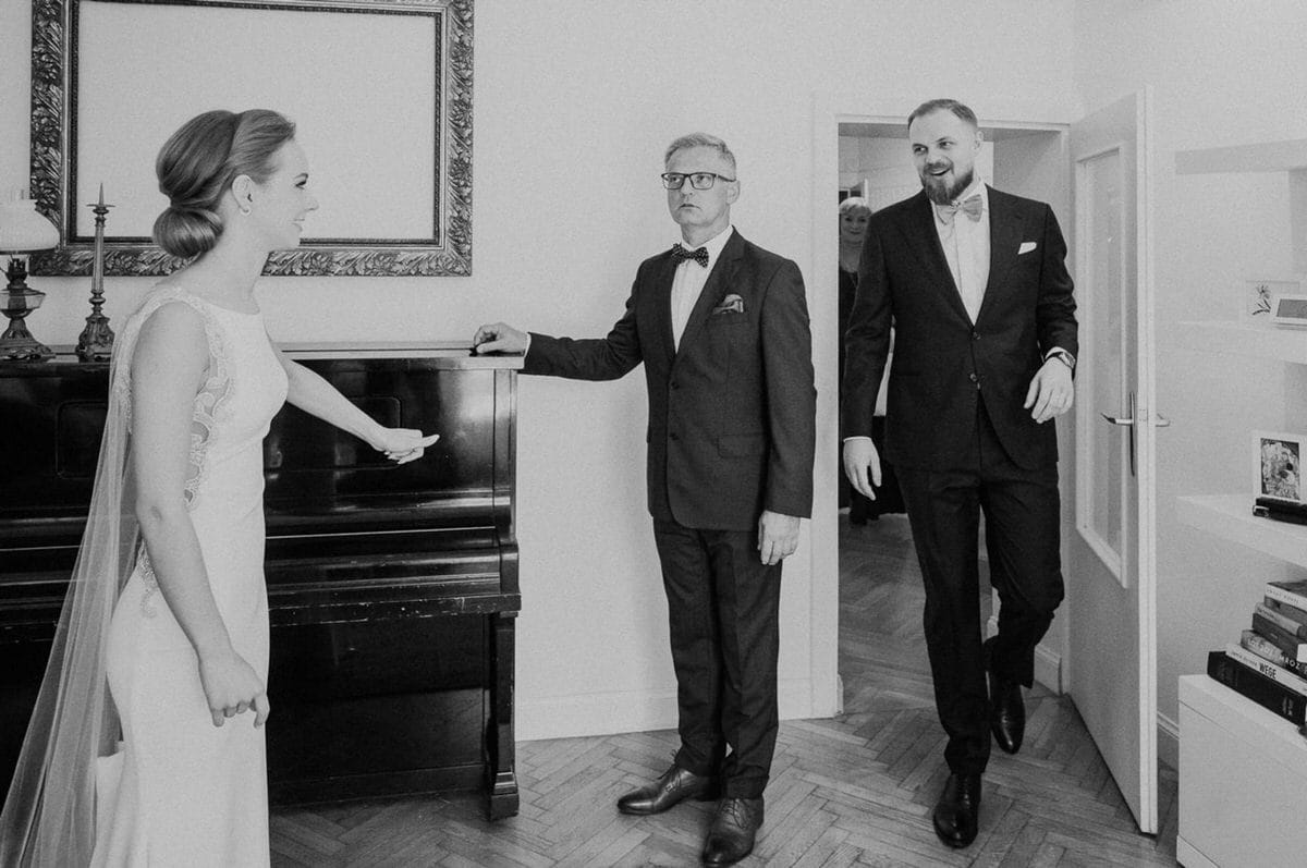 Para młoda z rodziną przed pianinem.