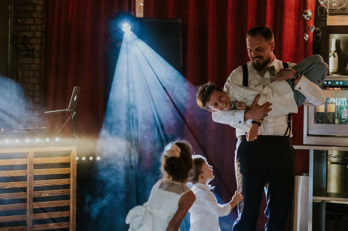 Mężczyzna bawiący się z dziećmi na przyjęciu.