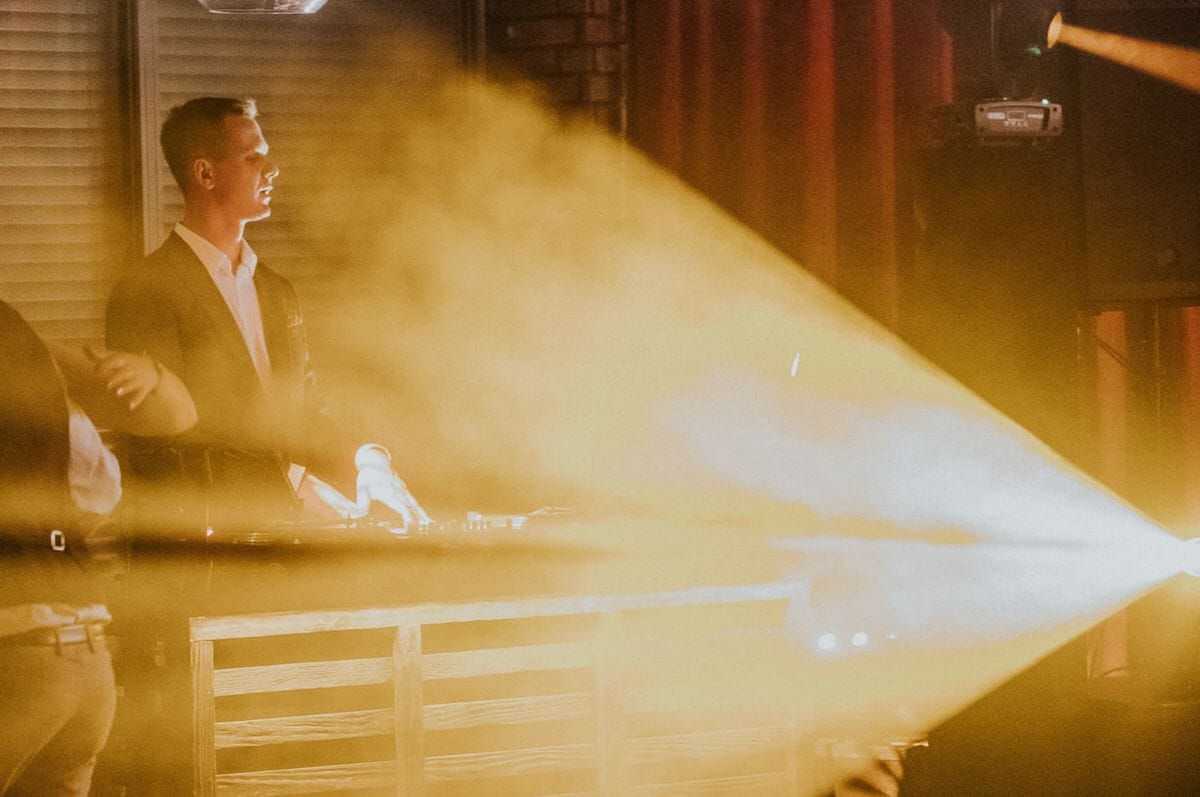 DJ na scenie oświetlonej światłami.