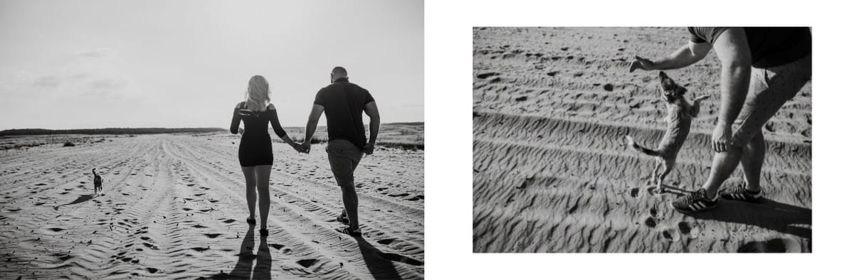 Para spaceruje po plaży, pies bawi się.