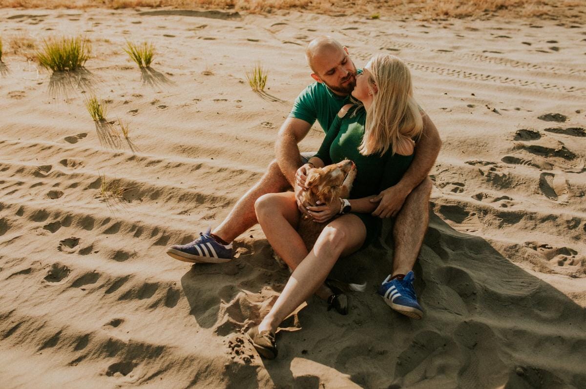 Para z psem na plaży, odpoczynek na piasku.