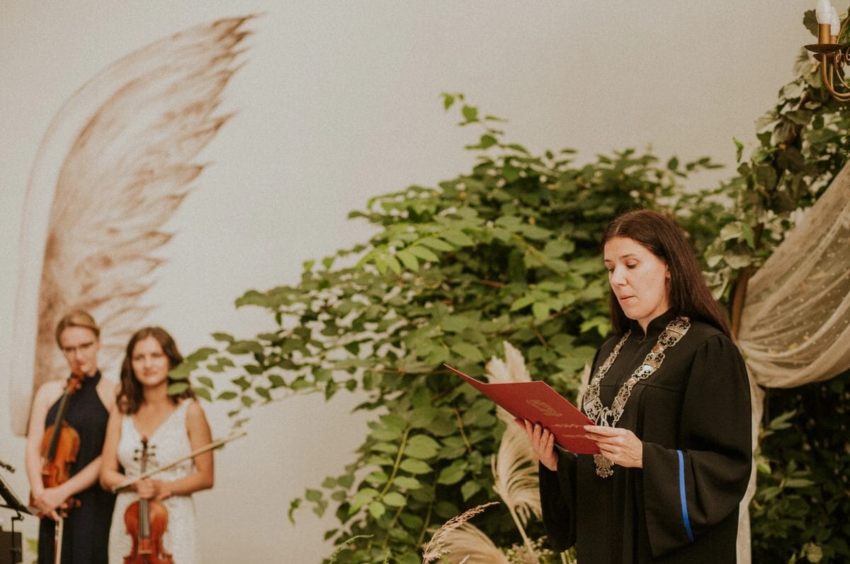 Ceremonia z udziałem skrzypaczek i osoby czytającej.