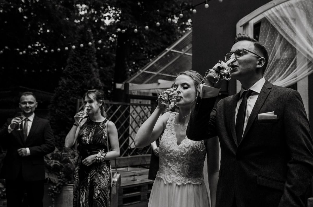 Młoda para pijąca toast na weselu.