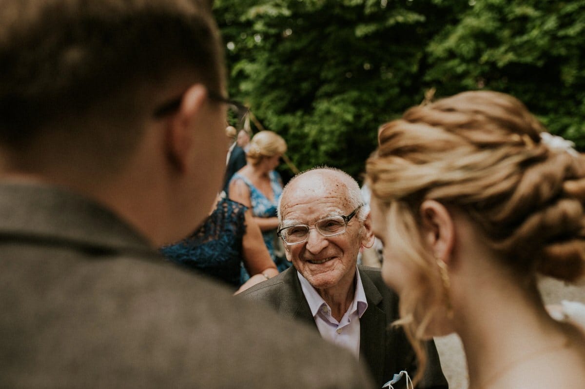 Uśmiechnięty starszy mężczyzna na przyjęciu w ogrodzie.