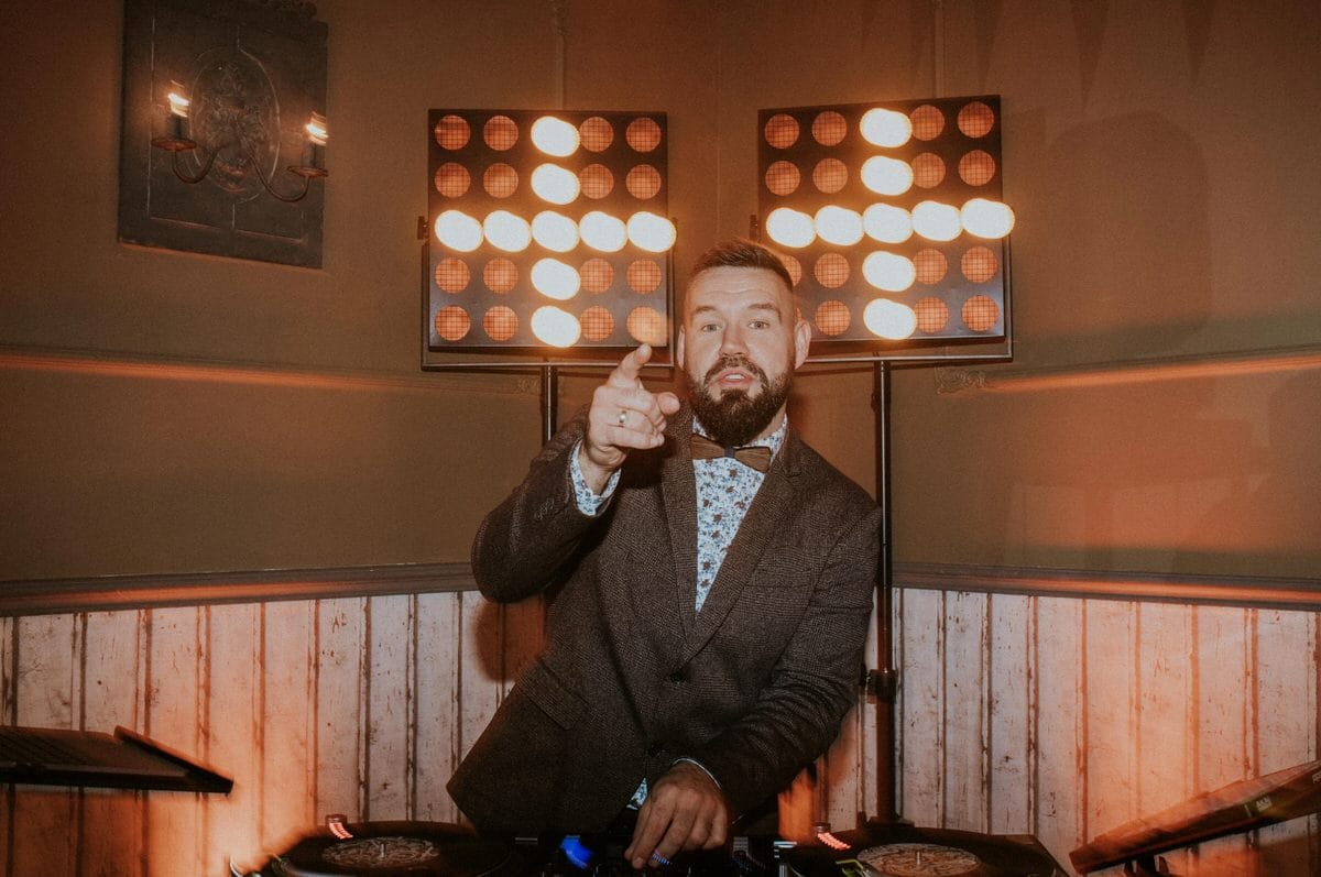 DJ na imprezie z oświetleniem scenicznym.