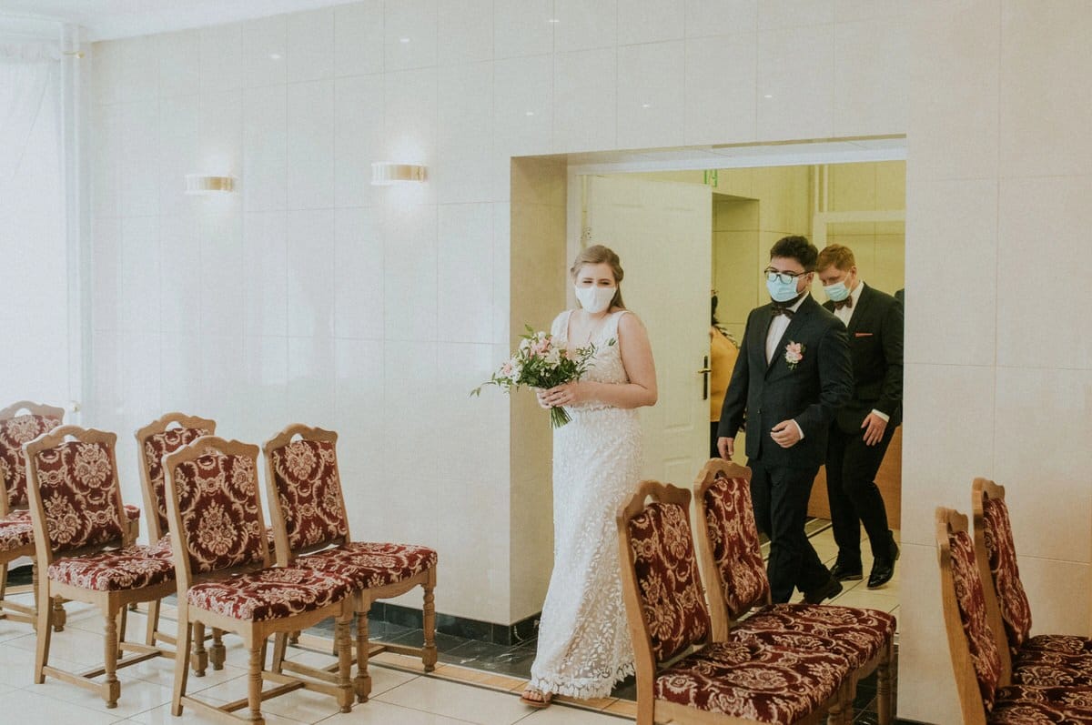 Panna młoda i goście w maseczkach, ceremonia ślubna.