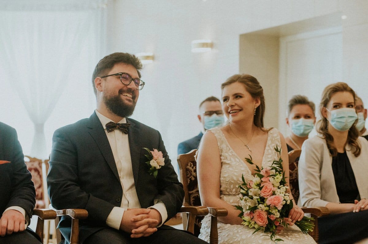 Para młoda podczas ceremonii ślubnej, z uśmiechem.