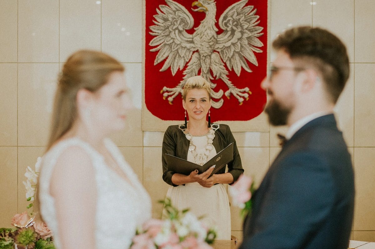 Ceremonia ślubna przed polskim godłem.