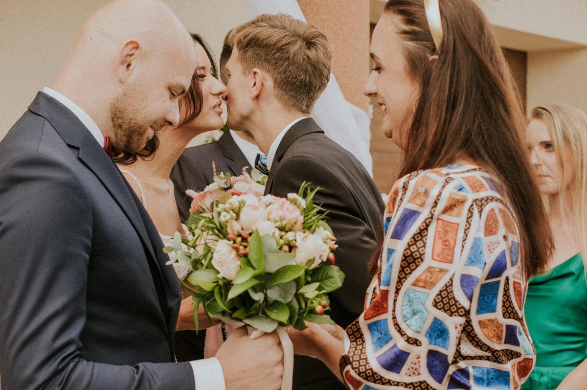 Ślubny moment z kwiatami i gośćmi.