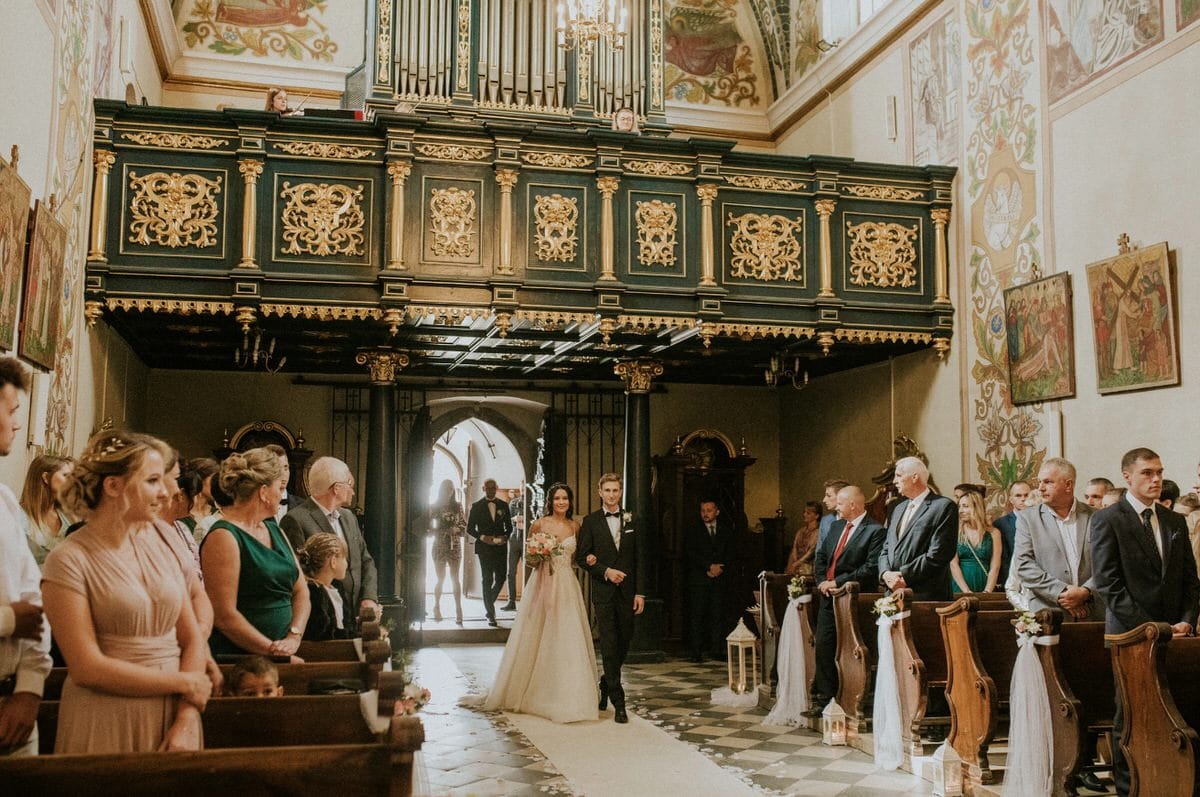 Para młoda wchodzi do kościoła na ceremonii ślubnej.