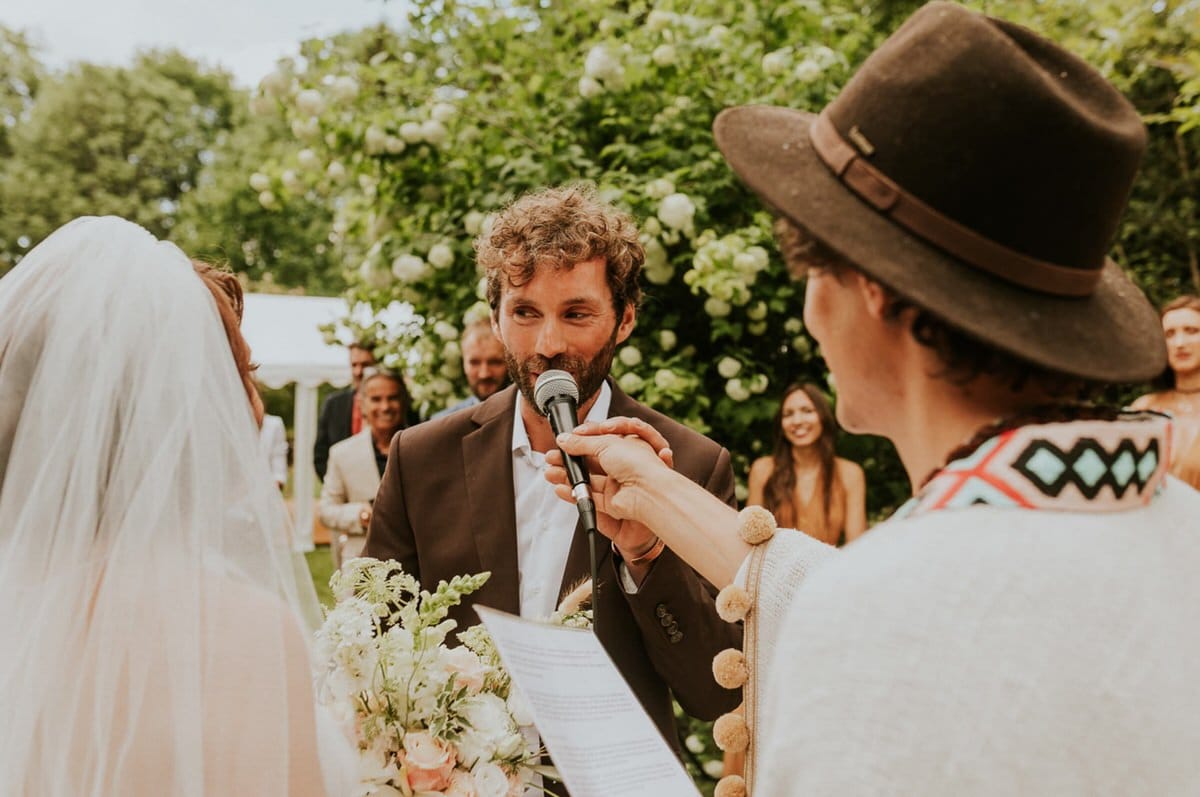 Ceremonia ślubna w ogrodzie, mężczyzna z mikrofonem.