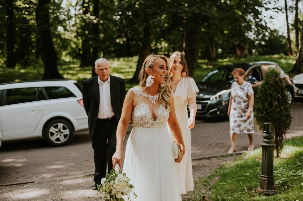 Panna młoda z gośćmi na weselu w parku.