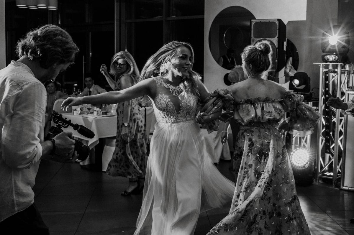 Ludzie tańczą na weselu, czarno-biała fotografia