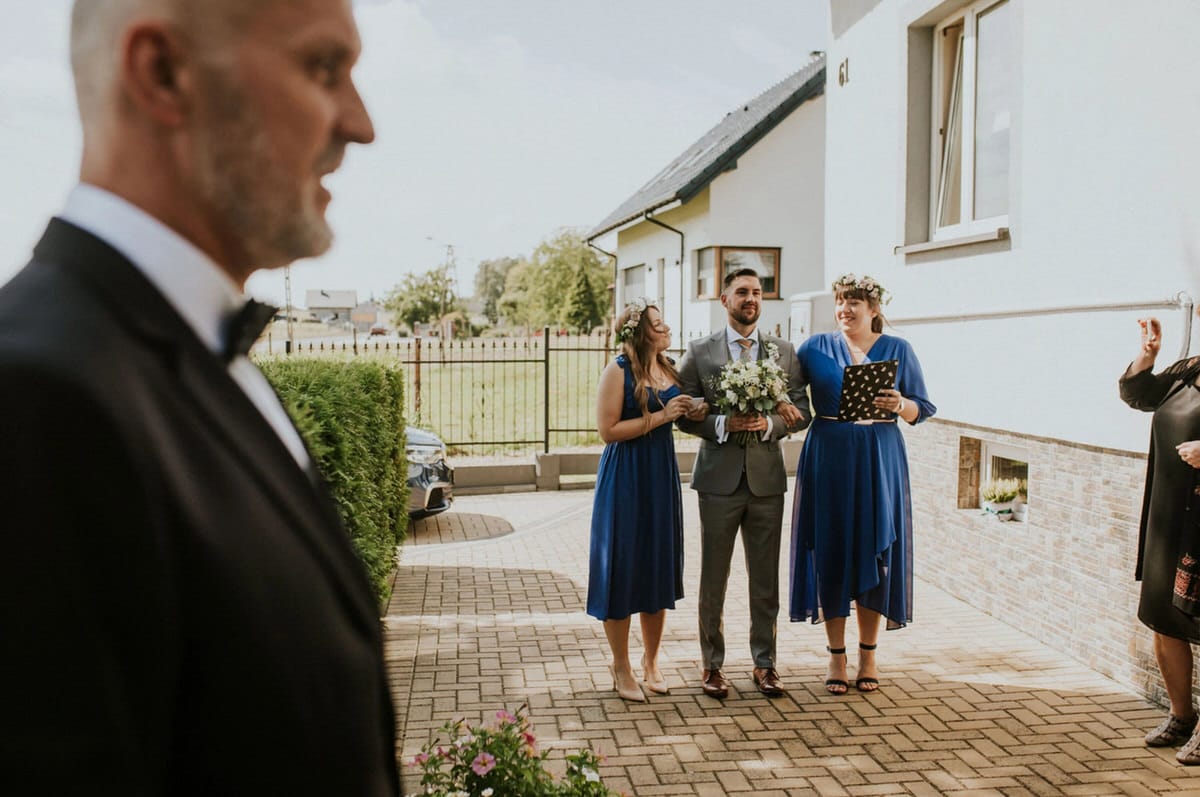 Para młoda na podwórku przed domem, ceremonia ślubna.