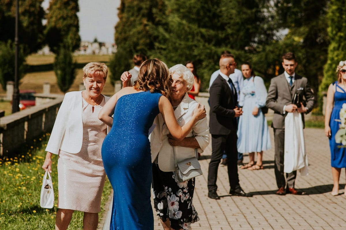 Ludzie witają się podczas uroczystości na świeżym powietrzu.