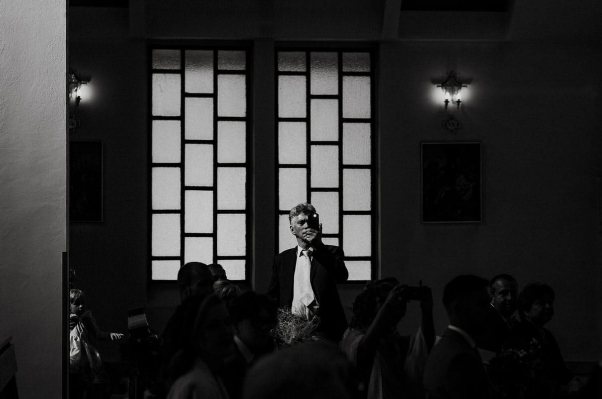 Mężczyzna w kościele, czarno-biała fotografia, refleksja.