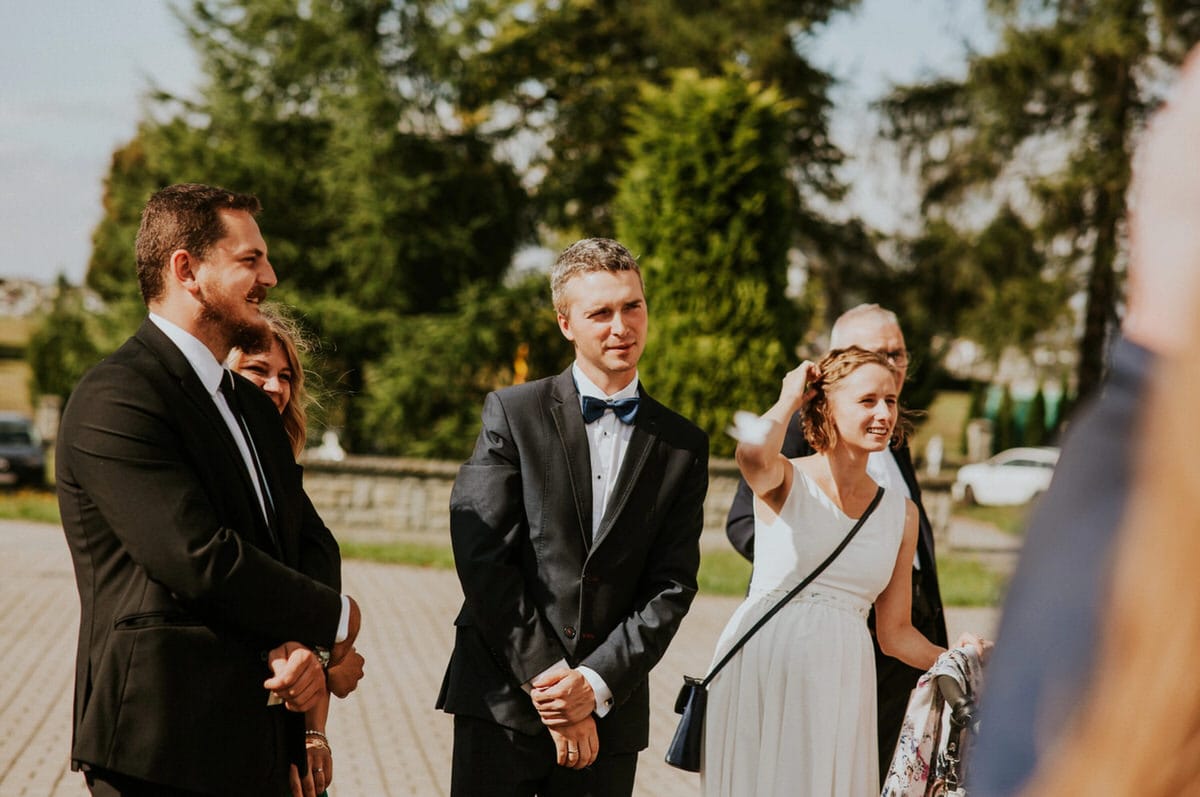 Grupa ludzi na eleganckim przyjęciu na zewnątrz.