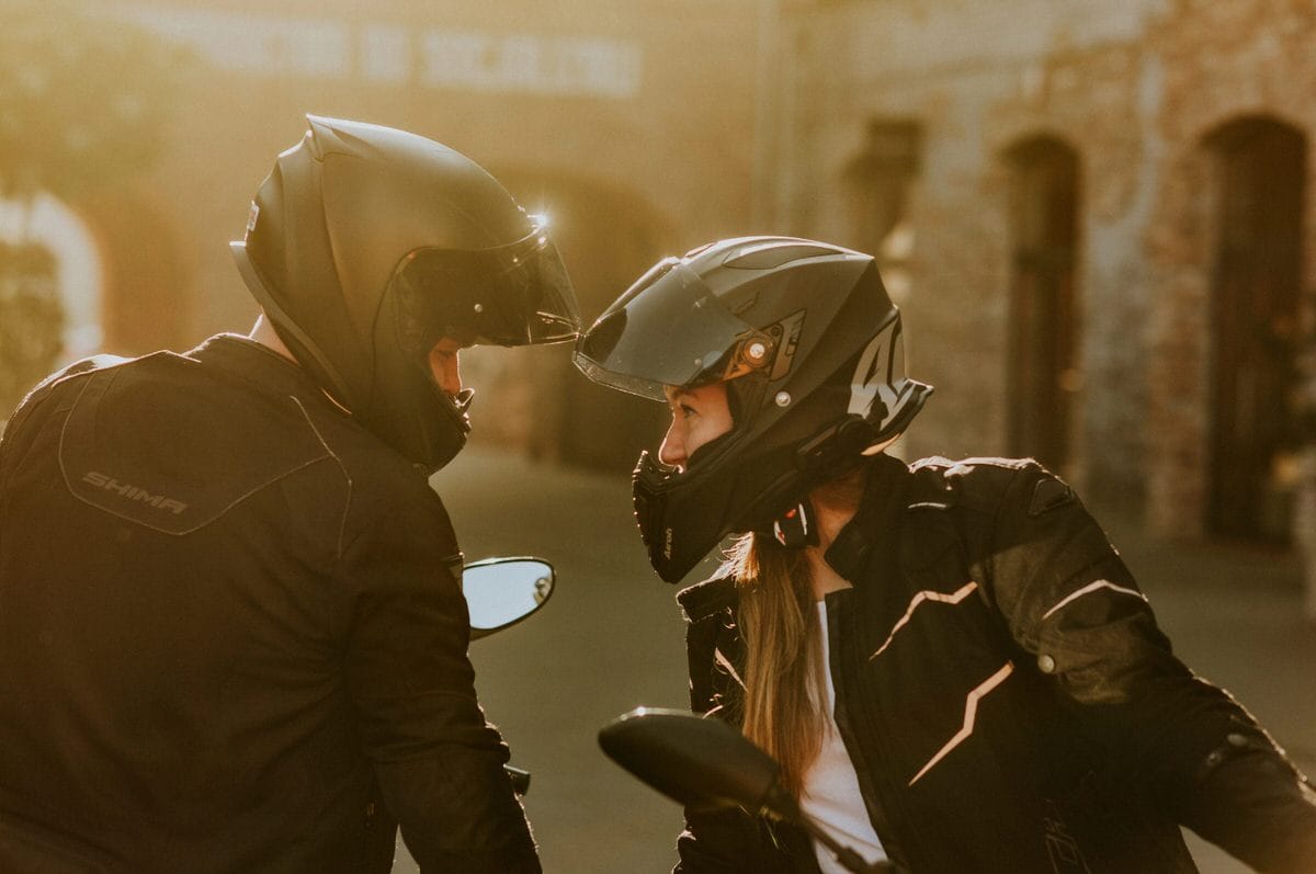 Dwie osoby na motocyklach rozmawiają w kaskach