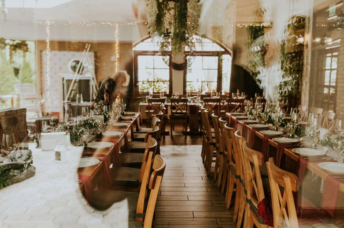 Elegancka sala weselna z ustawionymi stołami.