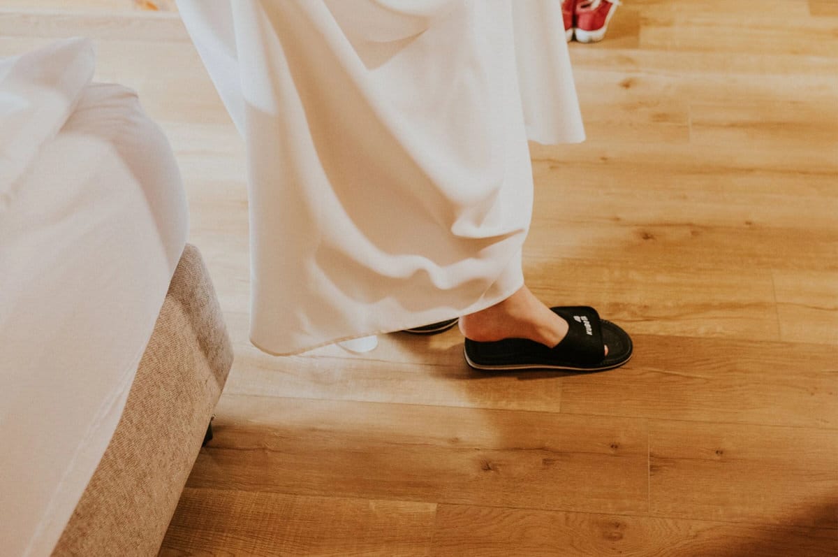 Osoba w kapciach na drewnianej podłodze