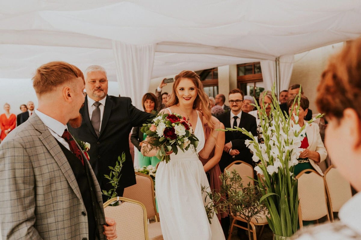 Panna młoda idzie do ołtarza wśród gości.