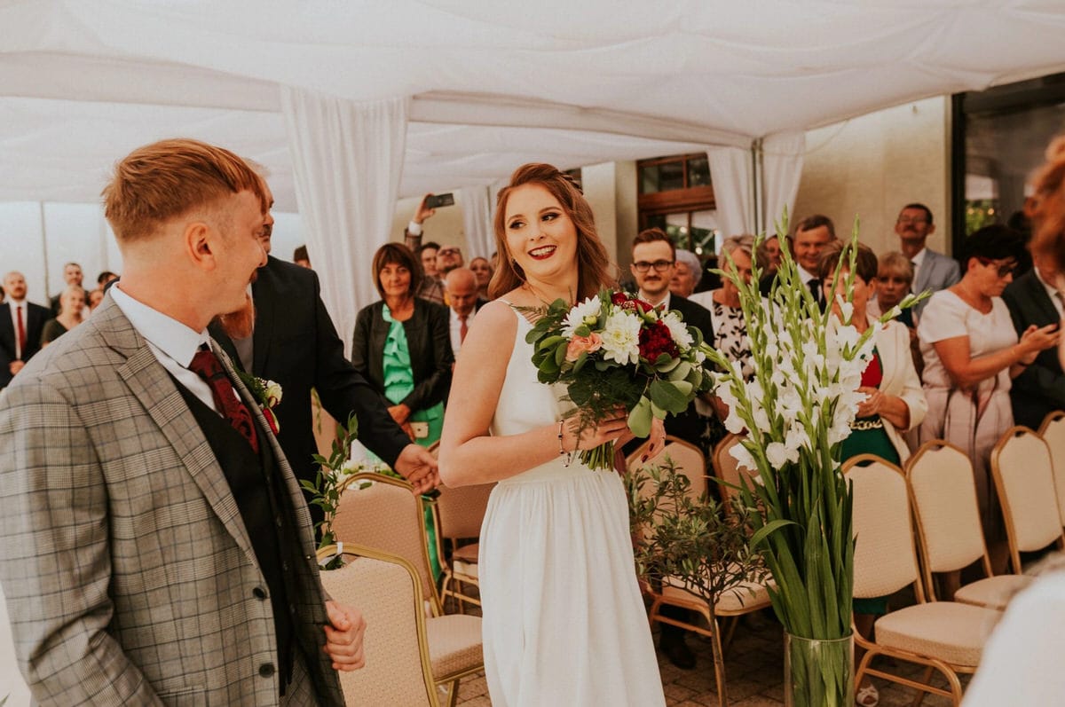 Ceremonia ślubna na świeżym powietrzu z uśmiechniętą parą