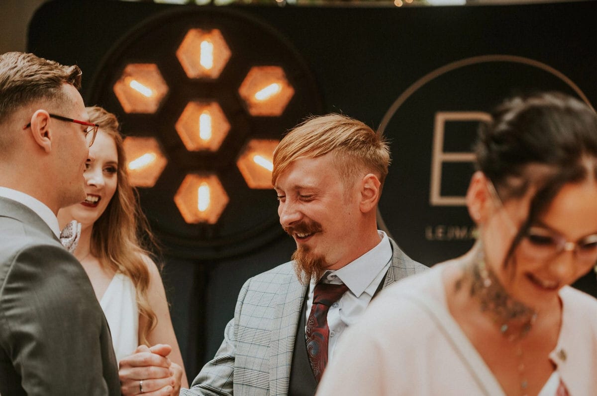 Grupa osób na eleganckim przyjęciu, światła w tle.