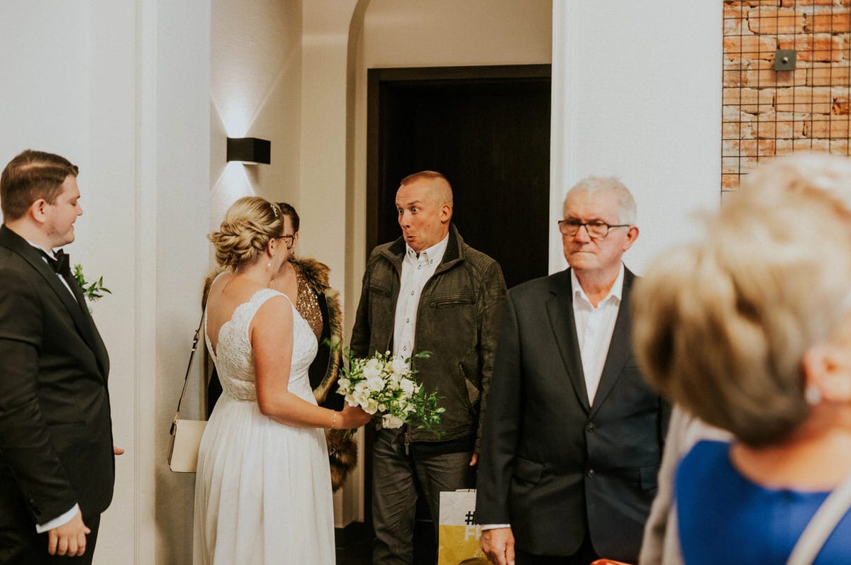 Goście weselni rozmawiają w sali.
