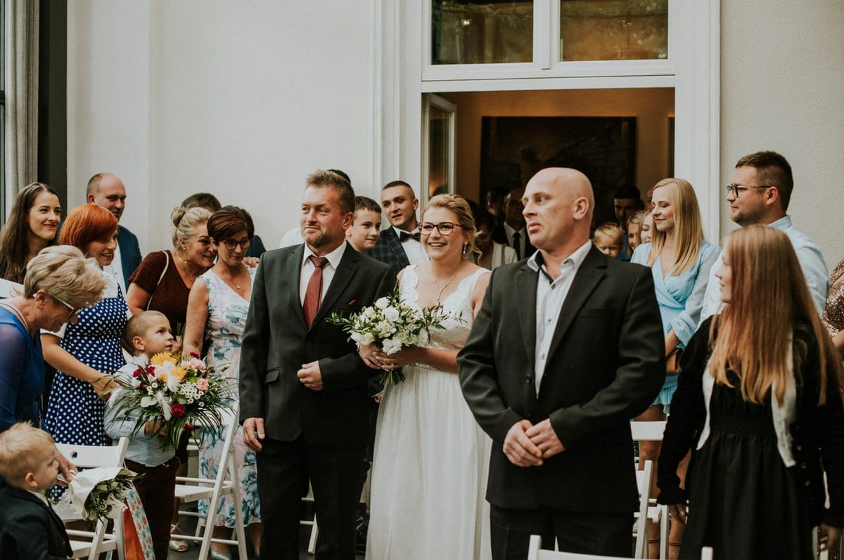 Uroczystość weselna z gośćmi i parą młodą.
