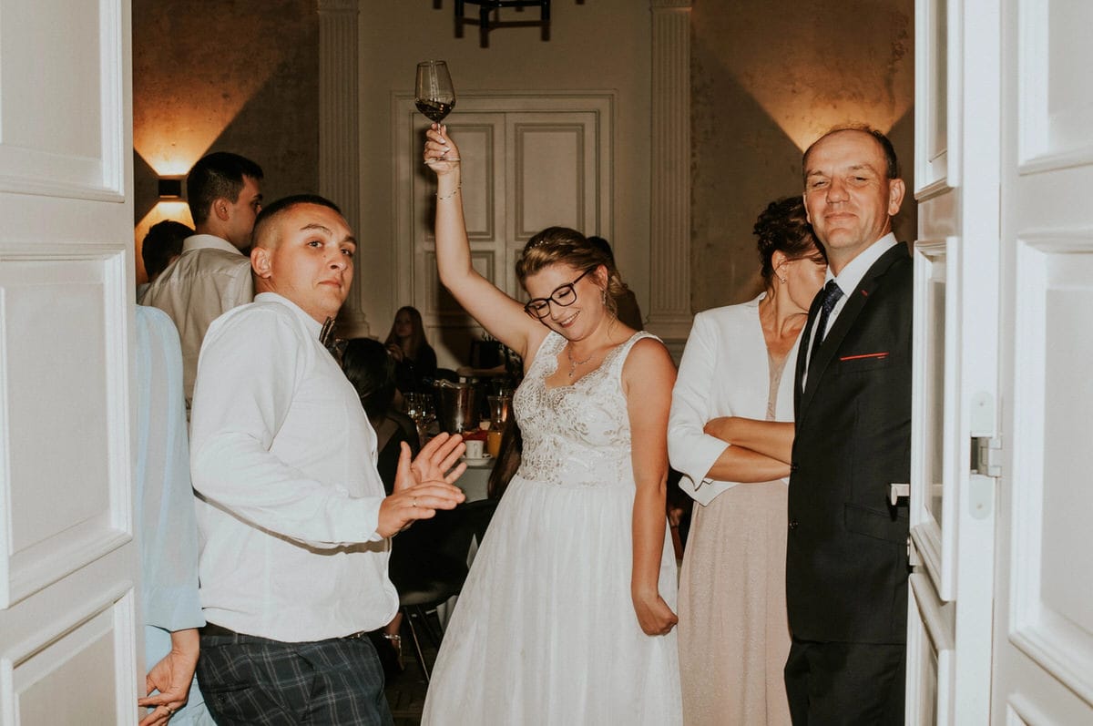 Ludzie świętujący na weselu, kobieta z kieliszkiem wina.