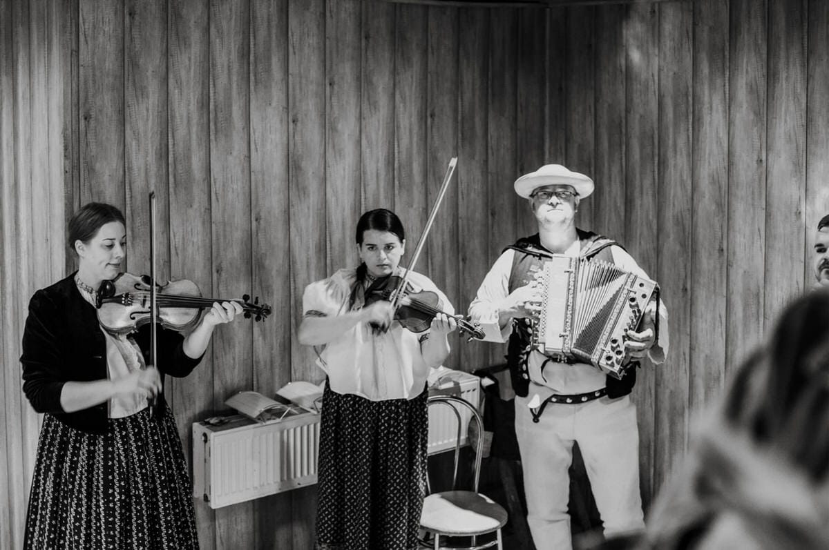 Zespół ludowy grający na skrzypcach i akordeonie.