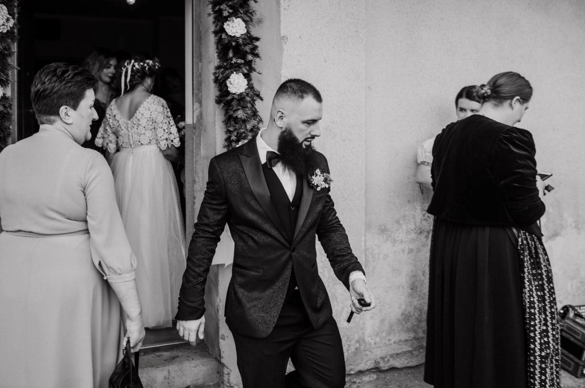 Goście weselni wychodzą z budynku, elegancka atmosfera