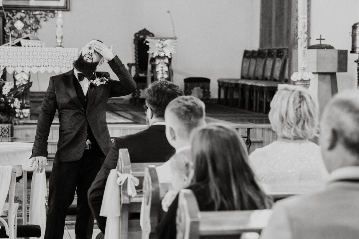 Pan młody w kościele podczas ceremonii ślubnej.