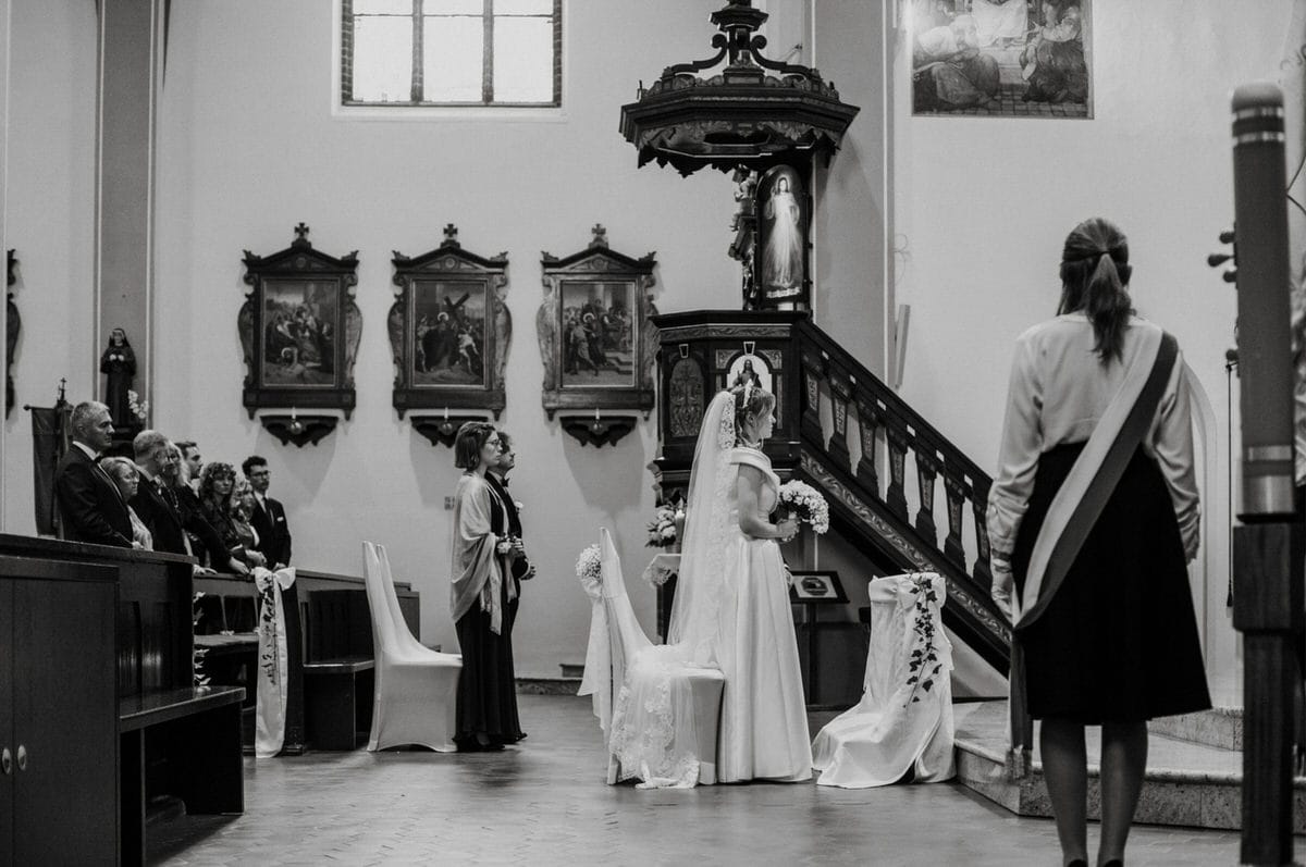 Ceremonia ślubna w kościele, panna młoda przy ołtarzu.