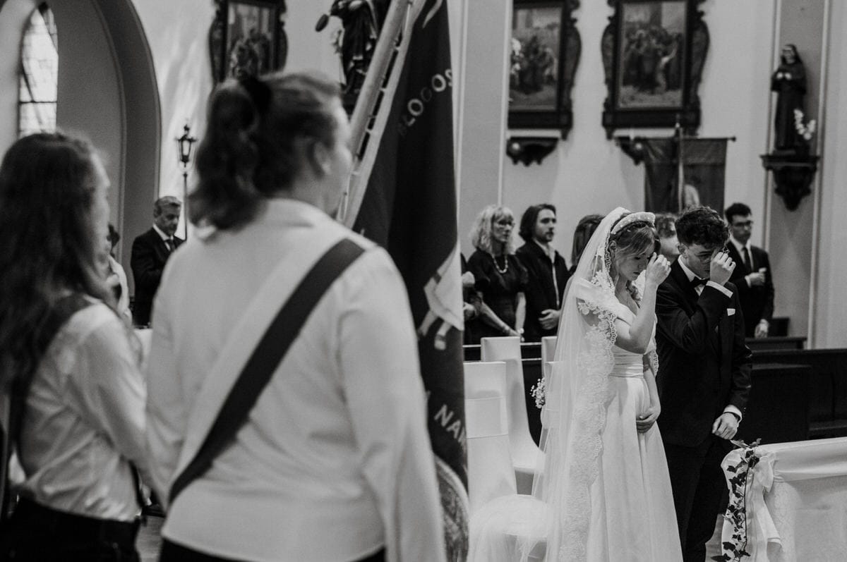 Ślubna ceremonia w kościele, młoda para wzruszona.