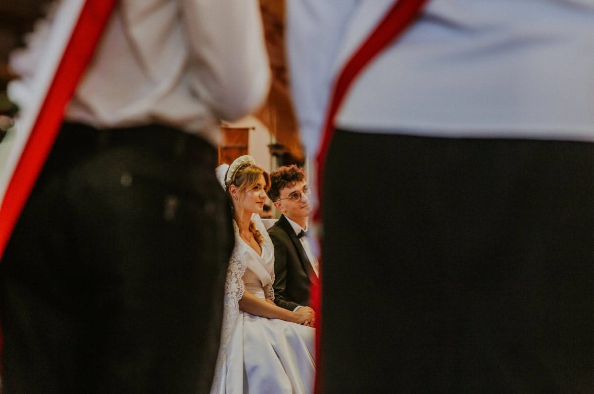 Para młoda siedzi podczas ceremonii ślubnej