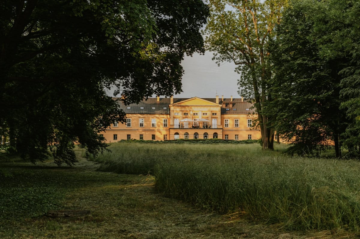 Zabytkowy pałac w zielonym otoczeniu