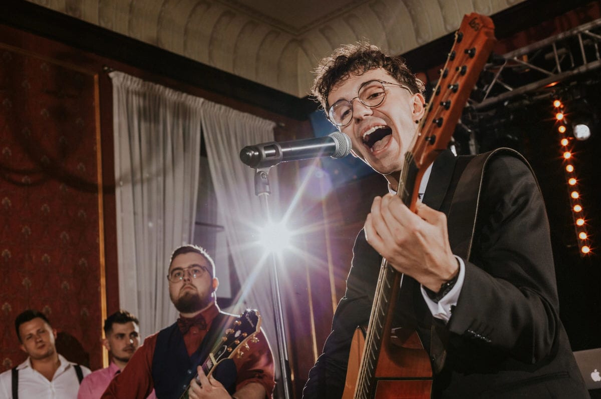 Zespół muzyczny występuje na scenie z gitarami.
