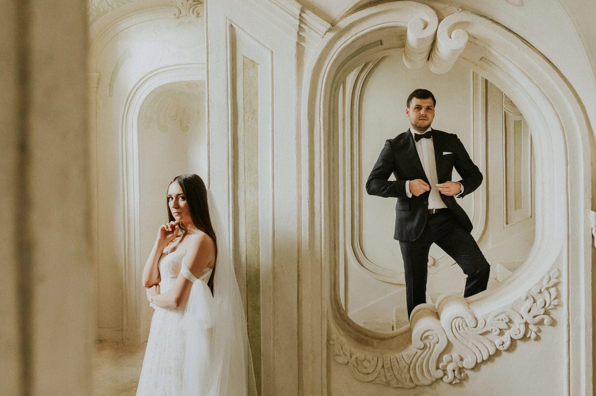 Para młoda w eleganckim wnętrzu, lustro i architektura.