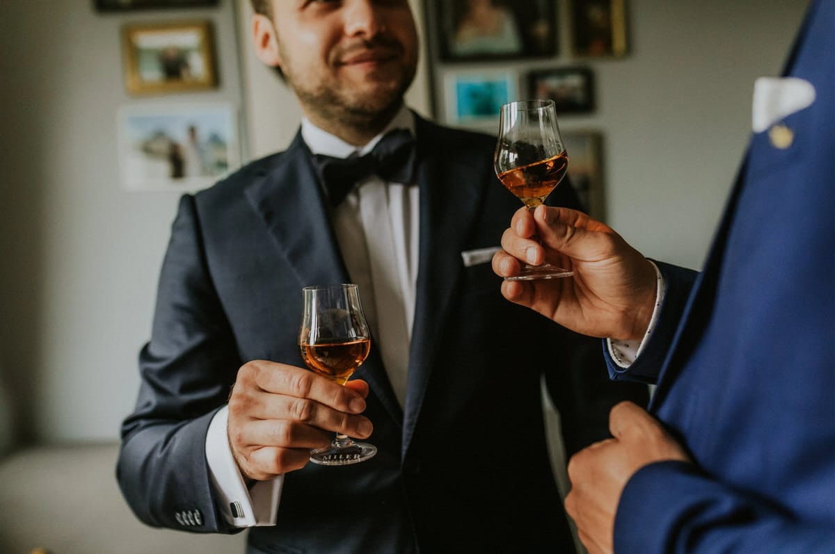 Dwóch mężczyzn w garniturach wznosi toast