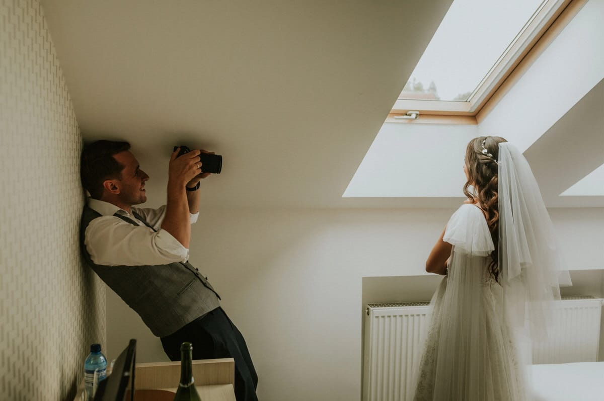 Fotograf i panna młoda w świetlistym pokoju.