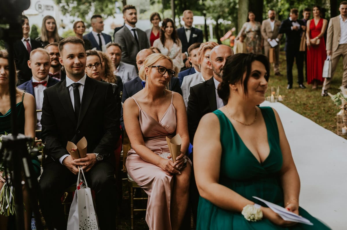 Goście siedzący na ceremonii na świeżym powietrzu.