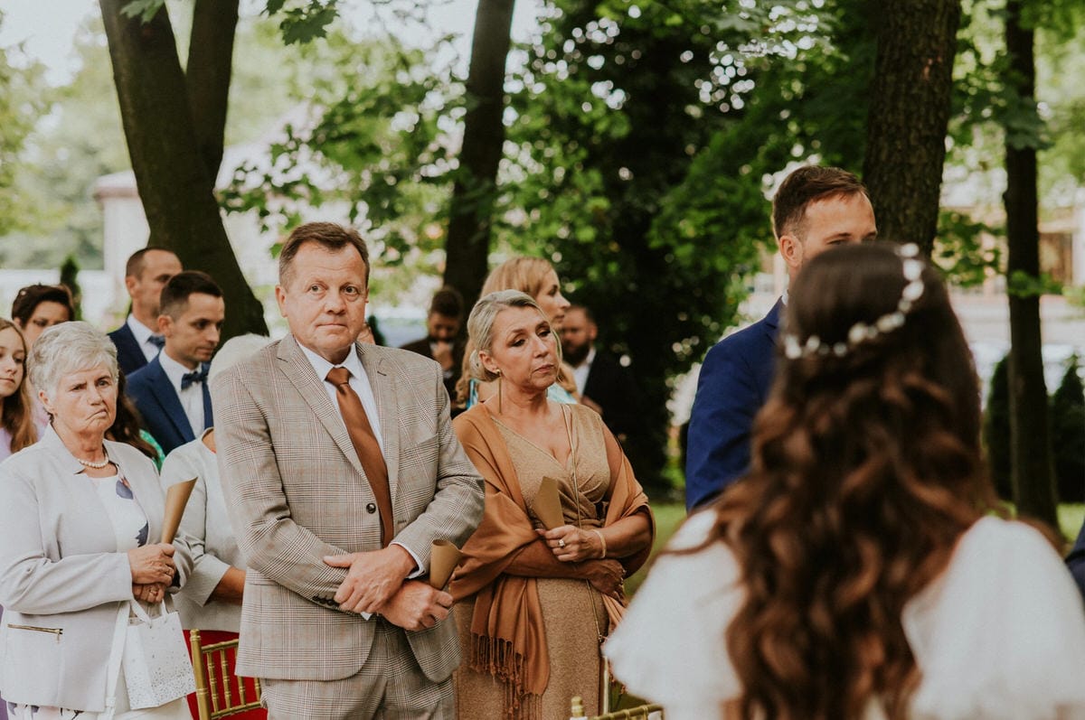 Ludzie na weselu w plenerze, skupieni mężczyźni i kobiety.