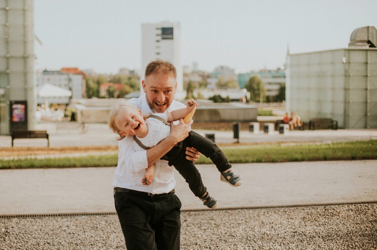 Szczęśliwy ojciec bawi się z dzieckiem w parku.