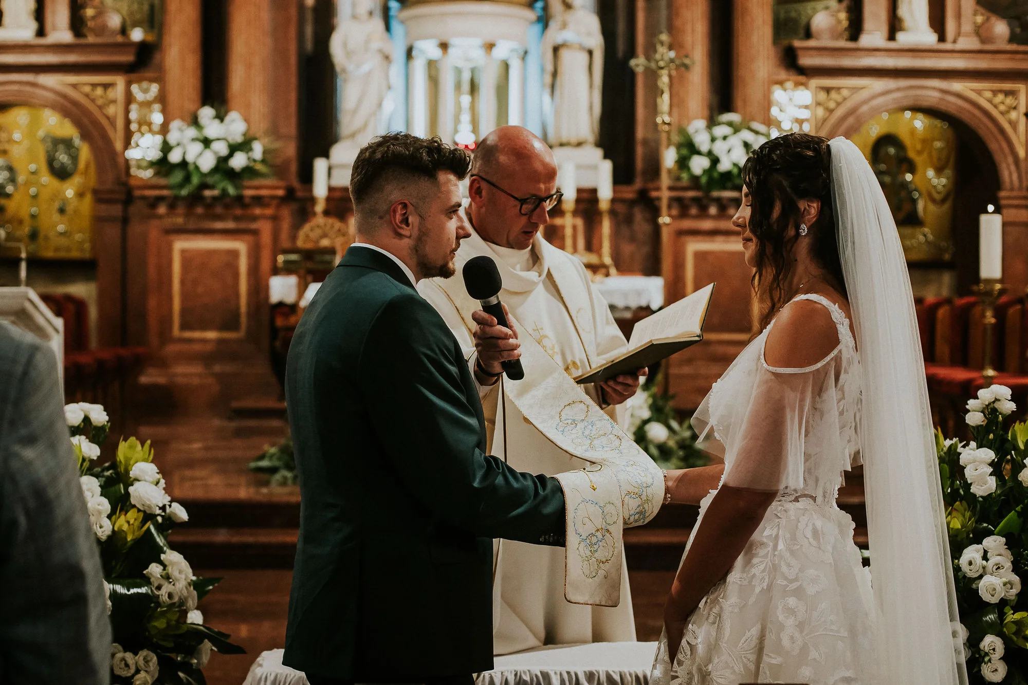 Ślub w kościele, młoda para z księdzem